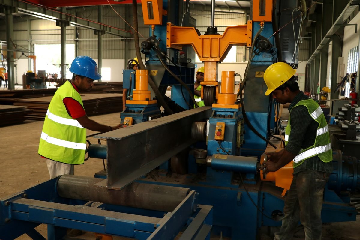 SteelCraft operators running a built-up steel beam through the automatic beam welding line at the Noakhali fabrication plant