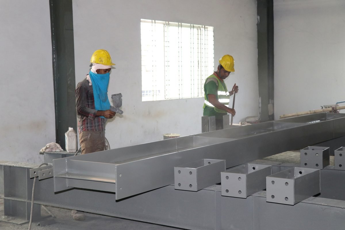SteelCraft workers priming fabricated steel beams and base plates before dispatch