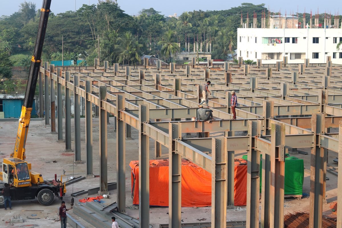 SteelCraft crew erecting a large-span pre-engineered steel frame with a mobile crane on site in Bangladesh